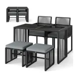 A compact bistro set with a black metal frame featuring a square table and four cushioned chairs that can be neatly tucked under the table for efficient space-saving storage.