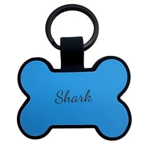 A blue, bone-shaped keychain with the name \“Shark\“ printed on it.