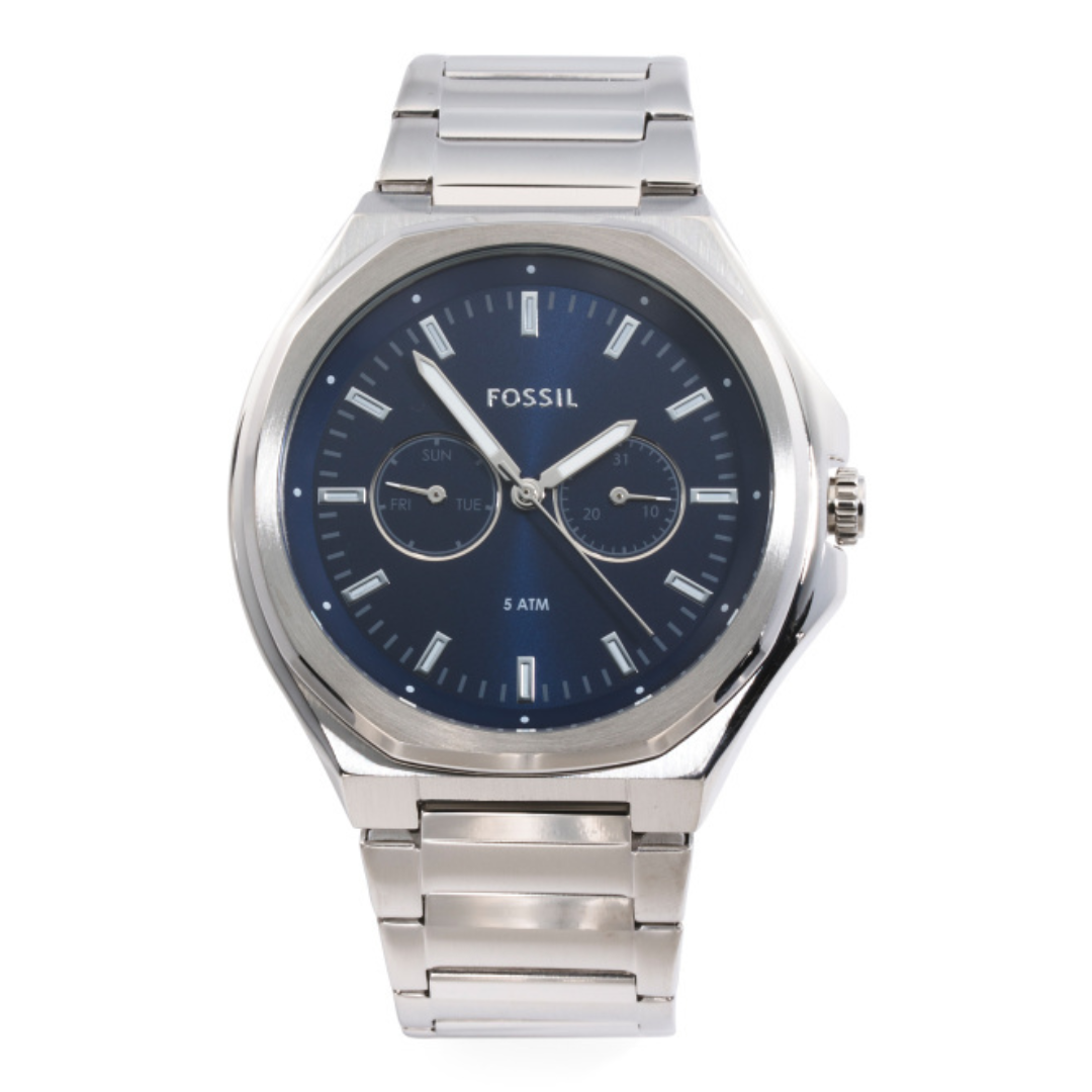 A Fossil men's watch with a silver metal bracelet, blue dial, and subdials displaying the day and date. The watch has a 5 ATM water resistance rating.