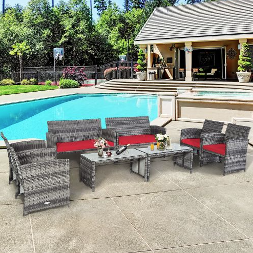 Outdoor patio furniture set includes a gray wicker seating arrangement with red cushions, featuring two sofas, two single chairs, and two coffee tables, placed near a pool and outdoor lounge area.