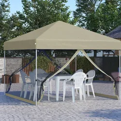 A beige canopy tent with open mesh sides covers a white table and several white plastic chairs, set on a stone patio surrounded by trees and a wooden fence.
