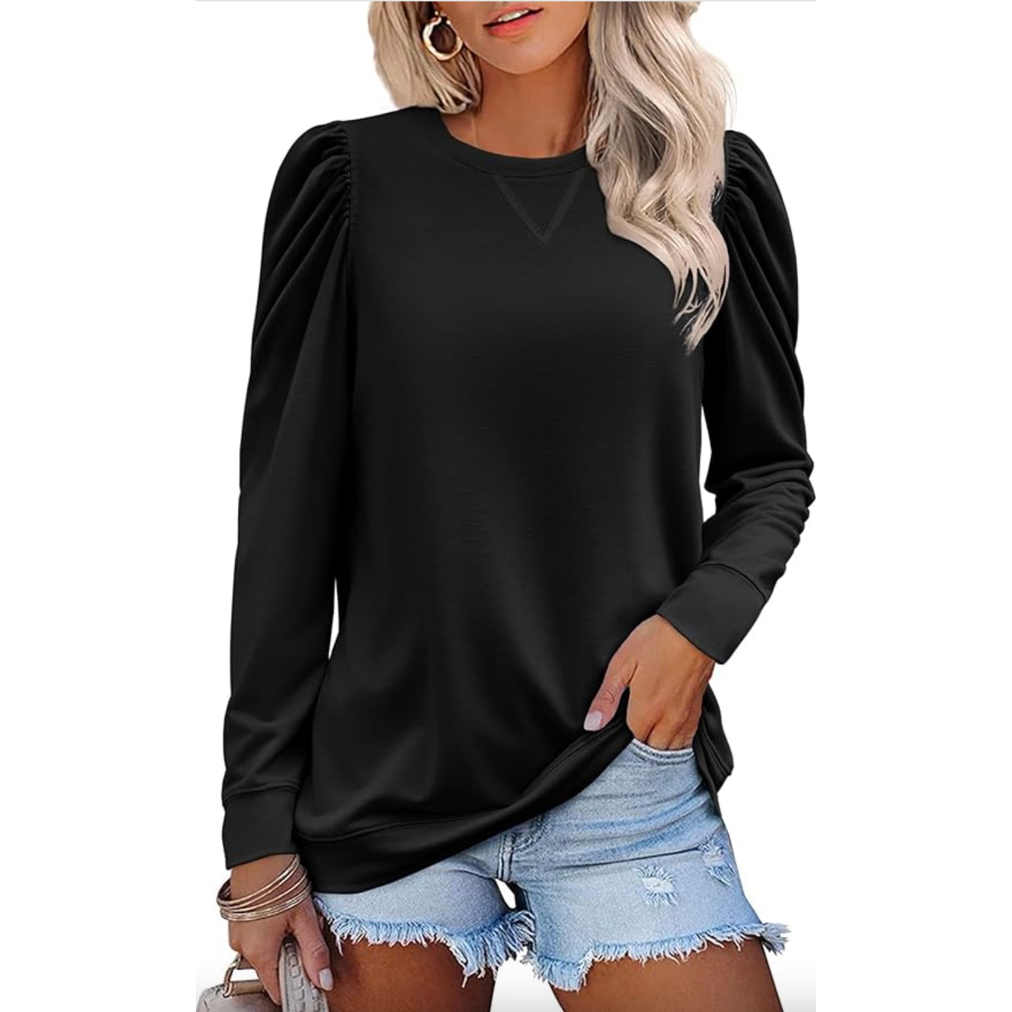 Black long-sleeve top with puffed shoulder details, paired with light denim shorts.