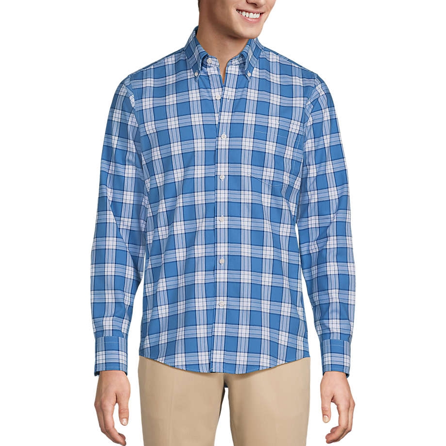 A man is wearing a blue and white plaid button-up shirt paired with khaki pants.