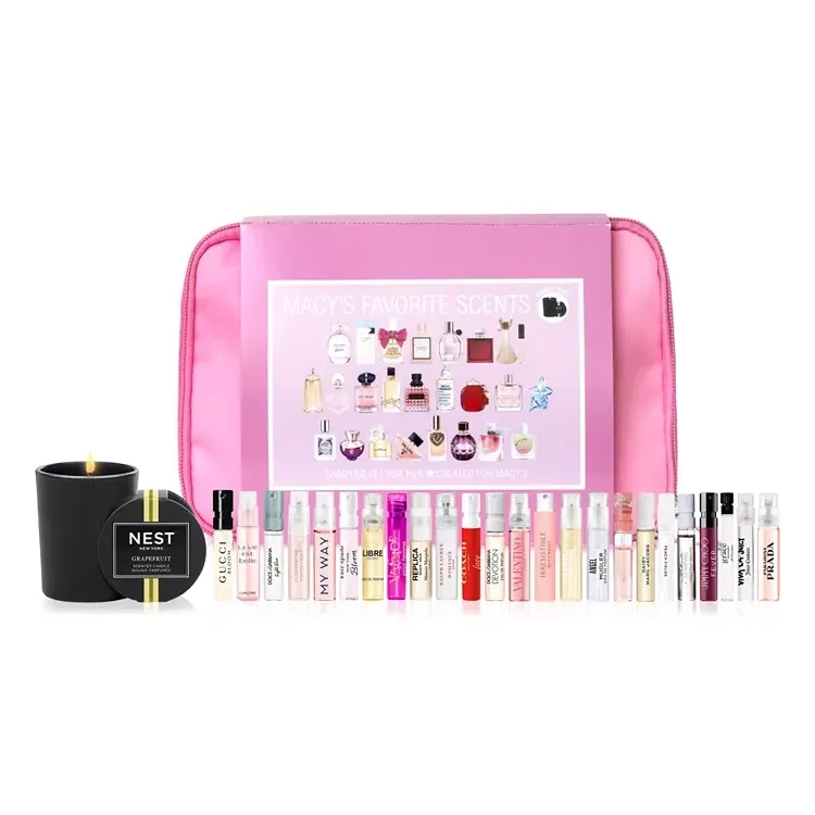 A pink cosmetic bag containing a variety of perfume samples, along with a black candle labeled 'NEST Grapefruit'.