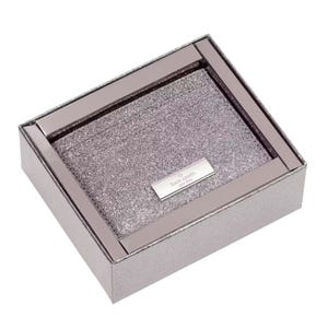 A glittery metallic box set containing a cardholder and keychain from Kate Spade New York, featuring a silver-tone logo plate on the cardholder.