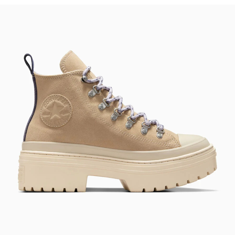 The Chuck Taylor Lugged Heel Platform is a beige high-top sneaker with a thick platform sole and rugged tread. It features round metal eyelets, light-colored hiking-style laces, and the classic Chuck Taylor star emblem on the side.