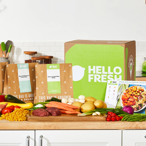 HelloFresh meal kit with ingredients such as carrots, potatoes, cherry tomatoes, mushrooms, and raw steak, includes recipe cards for \“Steak with Mushroom Cream Sauce\“ and \“Za'atar-Crusted Grilling Cheese.\“