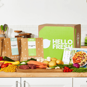 HelloFresh meal kit with ingredients such as carrots, potatoes, cherry tomatoes, mushrooms, and raw steak, includes recipe cards for \“Steak with Mushroom Cream Sauce\“ and \“Za'atar-Crusted Grilling Cheese.\“