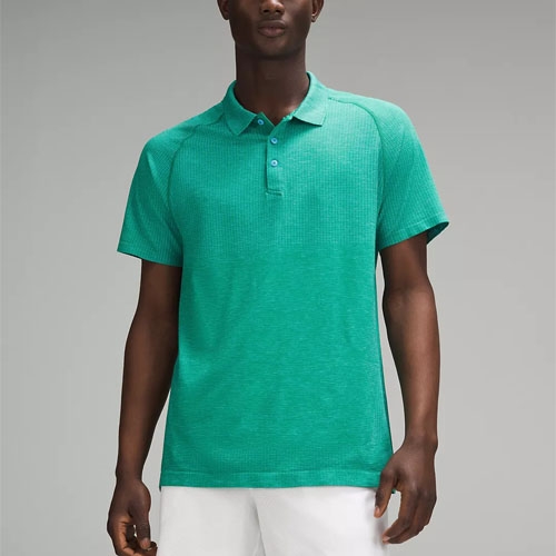 A man wearing a green polo shirt with a collar and buttons, paired with white pants.