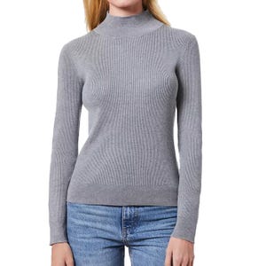 A gray, ribbed, long-sleeve mock-neck sweater paired with blue jeans. The sweater offers a fitted silhouette with a simple, elegant design.