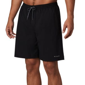 A person wearing plain black swim shorts with a drawstring waist.