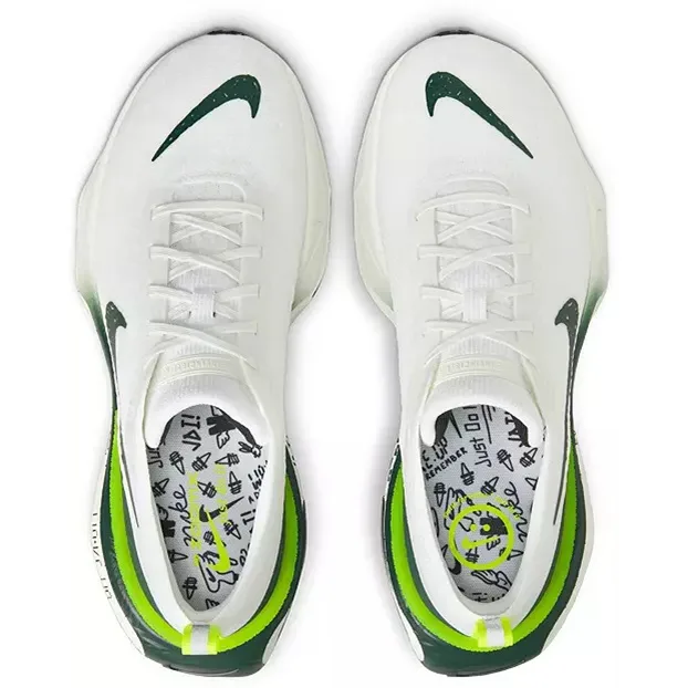 White Nike sneakers with green accents, viewed from above.