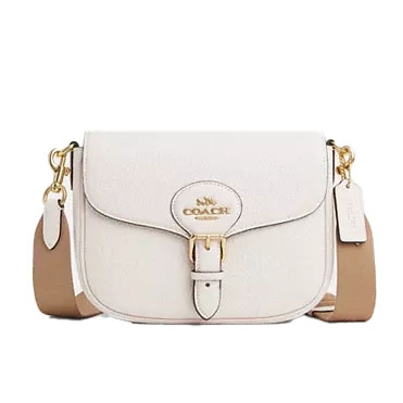 White Coach crossbody bag with gold hardware and a tan adjustable strap.