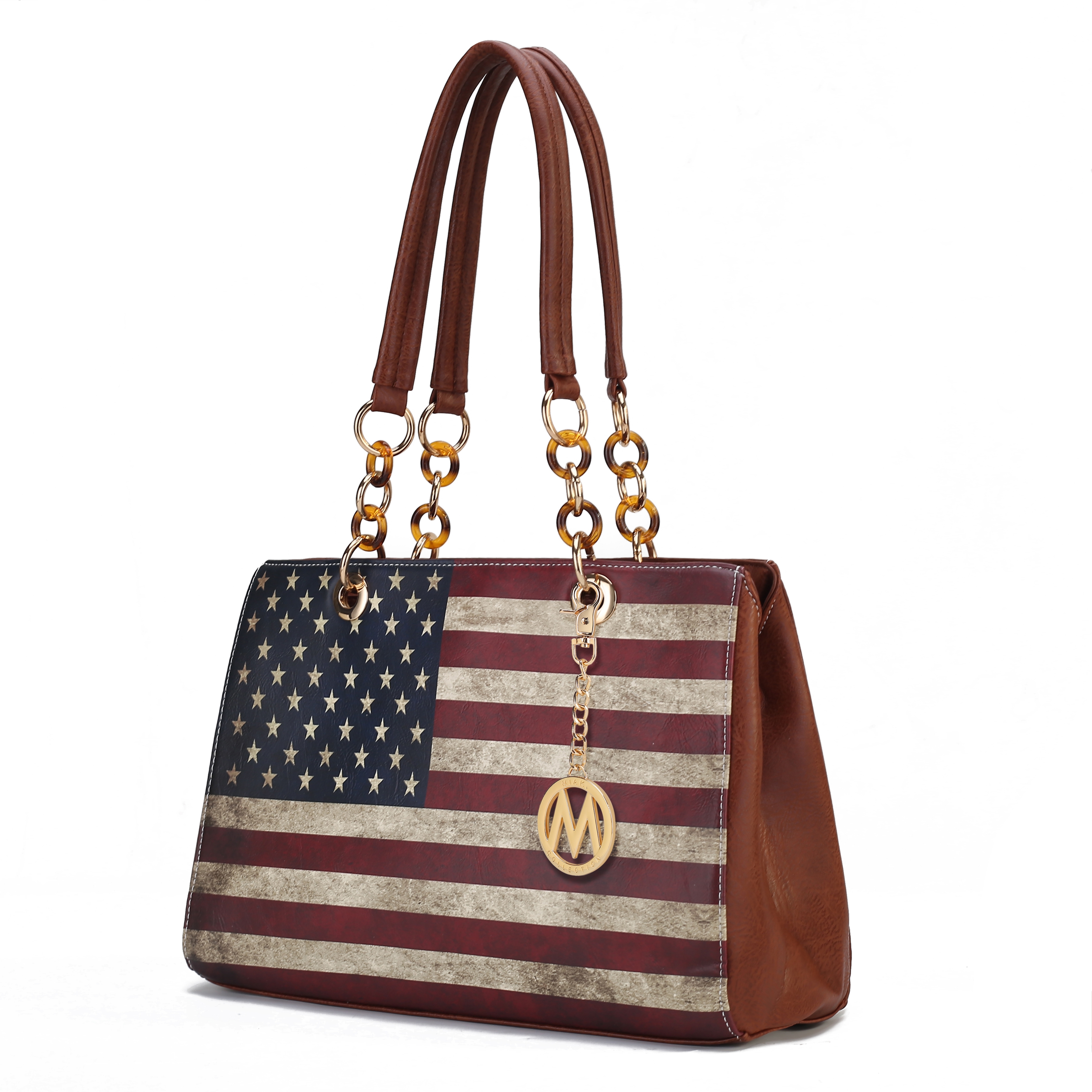 A handbag featuring the design of the American flag, with brown leather accents and gold chain straps. A circular gold pendant with a letter embellishes the bag.