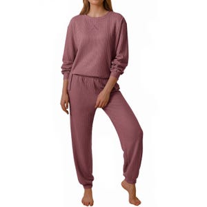The 2pc knit loungewear set includes a long-sleeve top and matching jogger pants in a soft, textured fabric. The outfit is designed for comfort and is shown in a muted rose color.