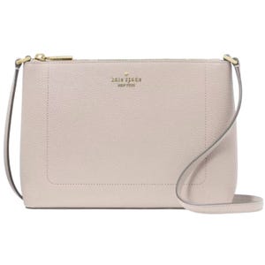 A minimalist beige Kate Spade leather crossbody bag featuring a gold zipper, logo, and an adjustable strap.
