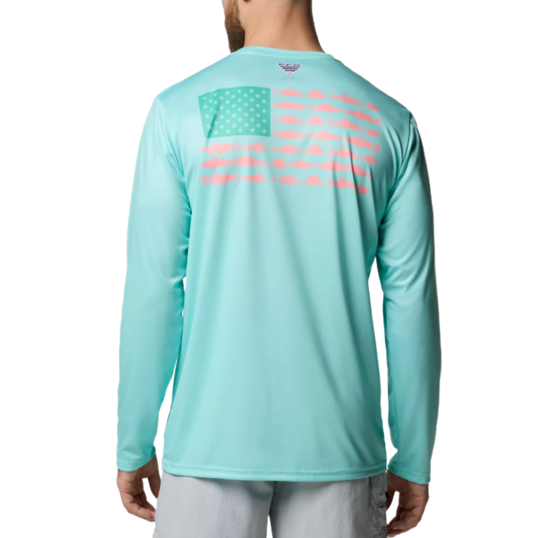 A man wears a light blue long-sleeve shirt featuring a stylized American flag made of fish shapes on the back.