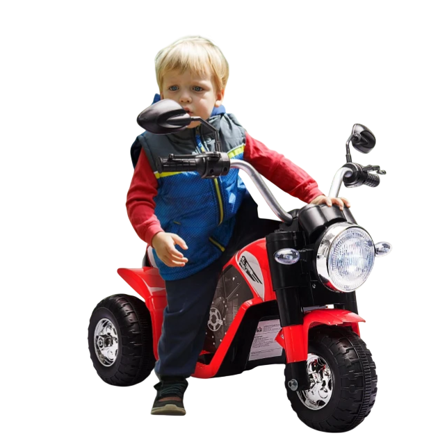 Child on a red electric ride-on tricycle with realistic motorcycle features, including mirrors and a headlight, riding on a path surrounded by greenery.