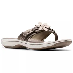 A brown sandal with a flower decoration on the strap, featuring a cushioned sole and white trim.