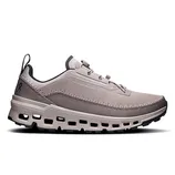 A taupe sneaker featuring a breathable mesh upper, cloud-like cushioning, and a distinctive sole with cut-out details for enhanced comfort and style.