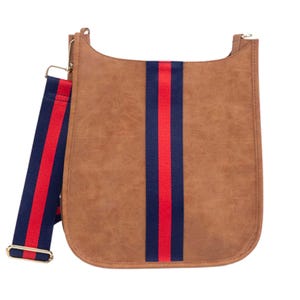 A tan faux leather shoulder bag featuring a red and navy blue striped strap and vertical accent.