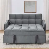 A gray tufted sofa bed with a pull-out bottom section is set against a neutral background, featuring curtains and a wall-mounted square artwork.