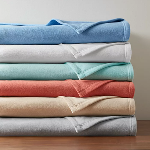 A stack of folded towels in various colors including blue, white, light teal, coral, beige, and gray.