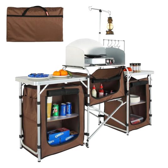 Portable outdoor kitchen station with a stove, countertops, storage shelves, and hooks, accompanied by a carrying bag.