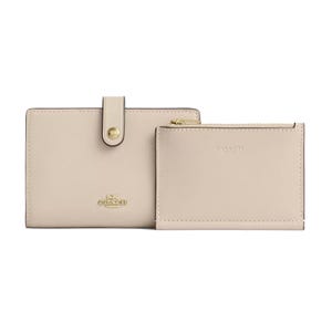 A beige Coach wallet and pouch set featuring gold-tone hardware and a zippered compartment.