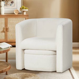 White accent chair with rounded edges and a matching storable ottoman, set in a cozy room with warm tones and natural wood textures.