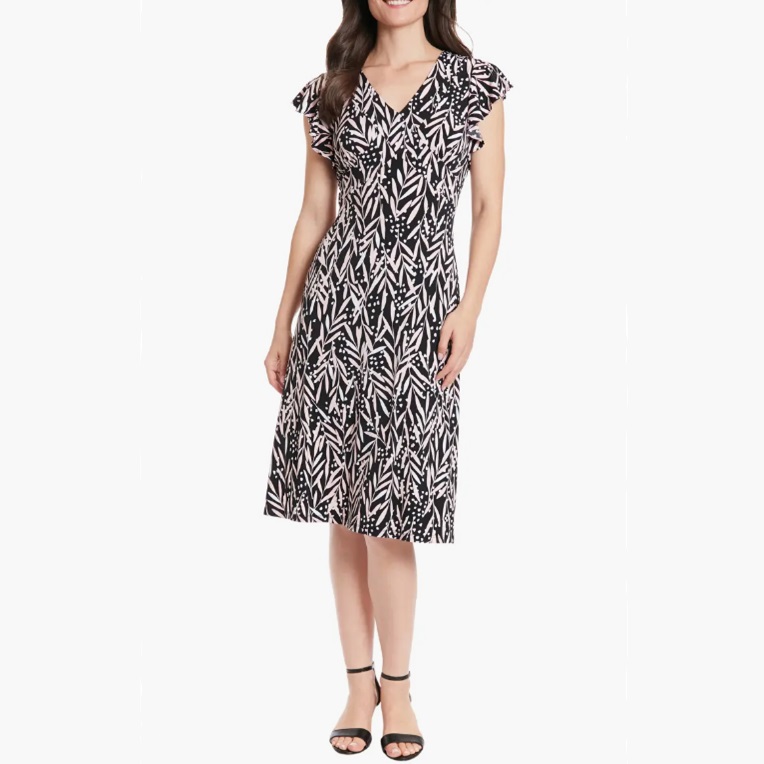 A black and white patterned knee-length dress with short flutter sleeves and a V-neckline, paired with black ankle-strap sandals.