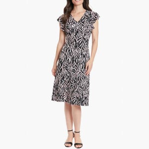 A black and white patterned knee-length dress with short flutter sleeves and a V-neckline, paired with black ankle-strap sandals.