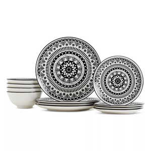 Black and white dinnerware set featuring plates and bowls with intricate geometric patterns.