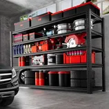 A garage shelving unit holds organized car repair tools and products, including boxes, tire rims, a circular saw, various containers, tires, oil drums, and spray cans, all neatly arranged near a parked black car.