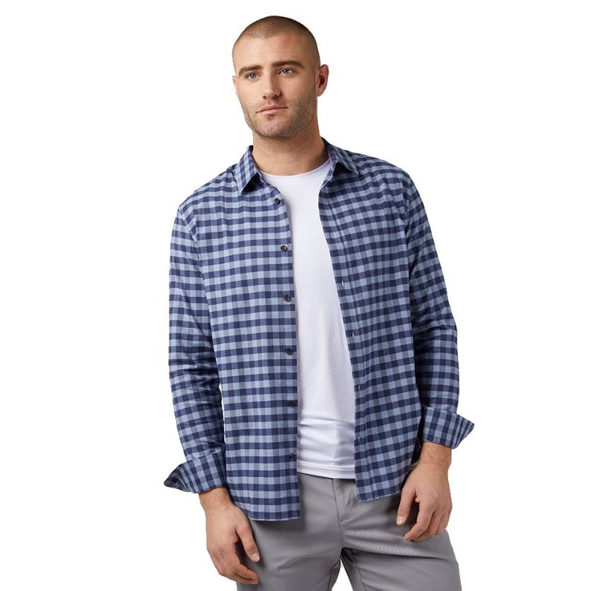 A man is wearing a blue and white checkered button-up shirt over a white T-shirt, paired with gray pants.