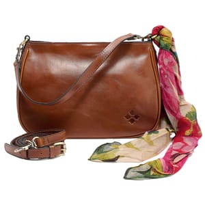 A brown leather shoulder bag with a floral patterned scarf tied at the strap, featuring a small embossed logo, and a detachable strap with brass hardware.