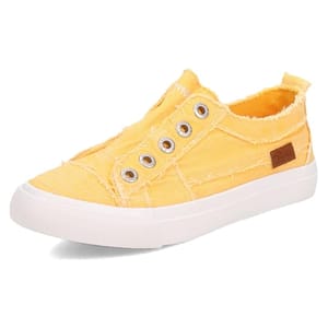 A yellow slip-on sneaker with a frayed canvas design, metal eyelets, and a white rubber sole.