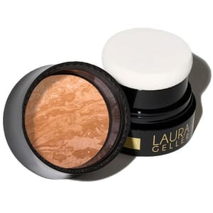 Laura Geller baked blush in a black container with a sponge applicator, featuring a marbled pattern in warm tones.