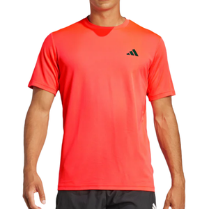 Red athletic t-shirt with a small black geometric logo on the chest, paired with dark shorts.