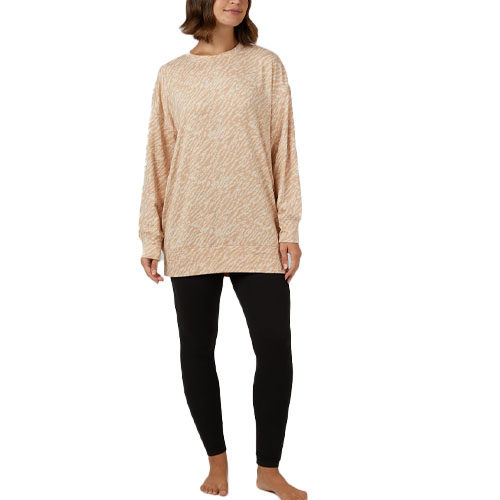 A woman is wearing a beige, plush, long-sleeve top with a pattern of subtle lines paired with plain black leggings.
