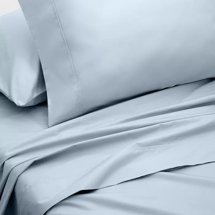 A light blue bed sheet set featuring a pillowcase and a flat sheet with a smooth, matte finish.