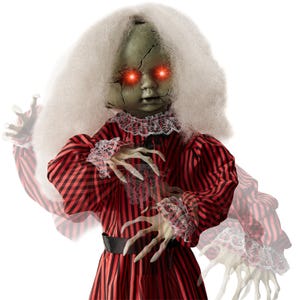 A creepy doll with glowing red eyes, cracked face, long white hair, and a red striped dress.