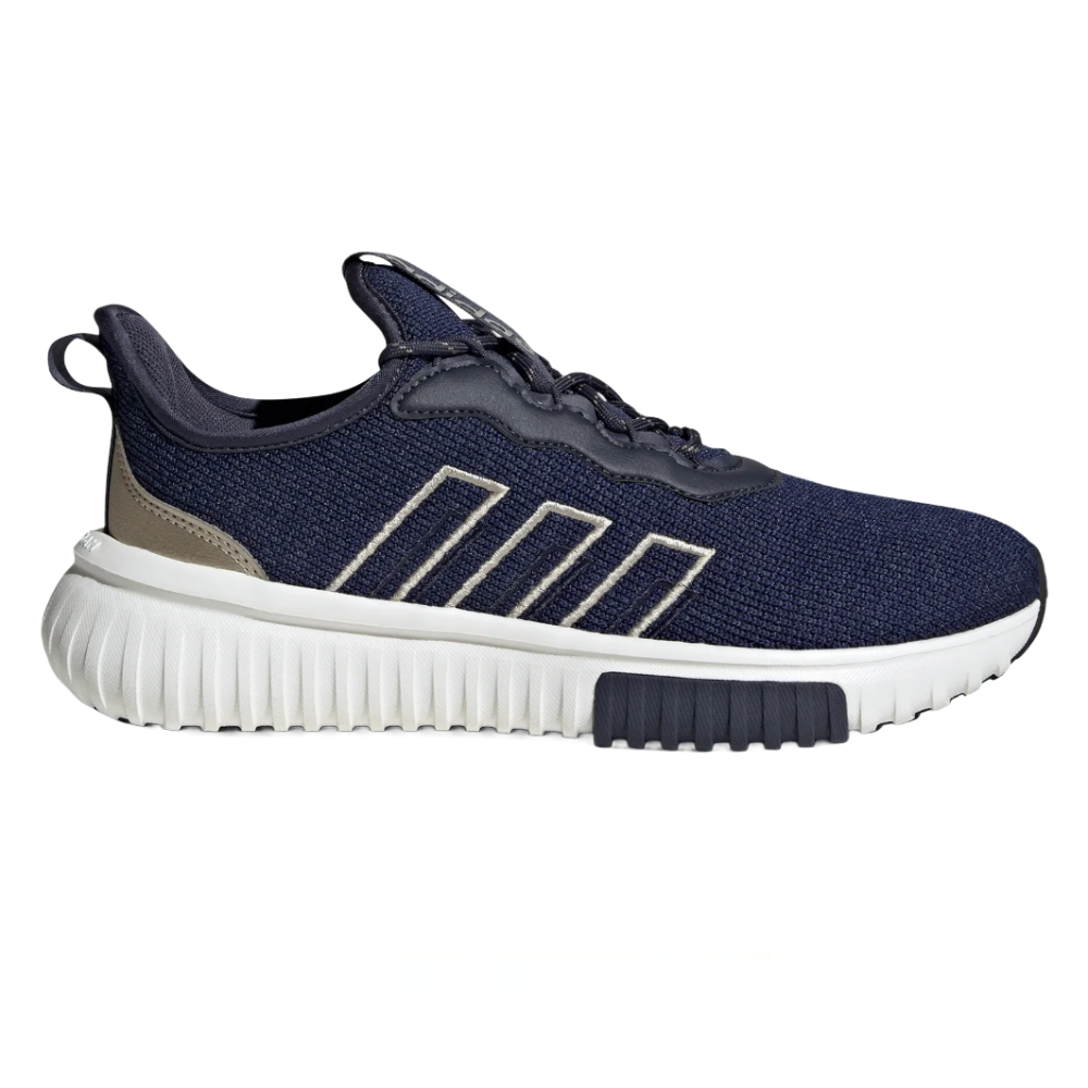 A navy and beige athletic shoe featuring a textured upper, distinctive striped design on the side, and a ribbed white sole with a black traction pad.