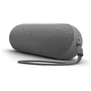 A gray cylindrical Bluetooth speaker with a textured grill, water droplets, and a carrying strap.