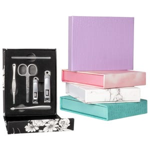 The 2pk Pop Sonic Nail Kits include a set of grooming tools like nail clippers, scissors, and a cuticle pusher, housed in decorative boxes with various patterns and colors, including black floral, marbled white, pink, purple, and teal.