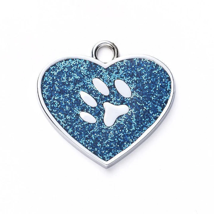 A heart-shaped, blue glitter pet tag features a paw print cutout and a small loop for attachment.