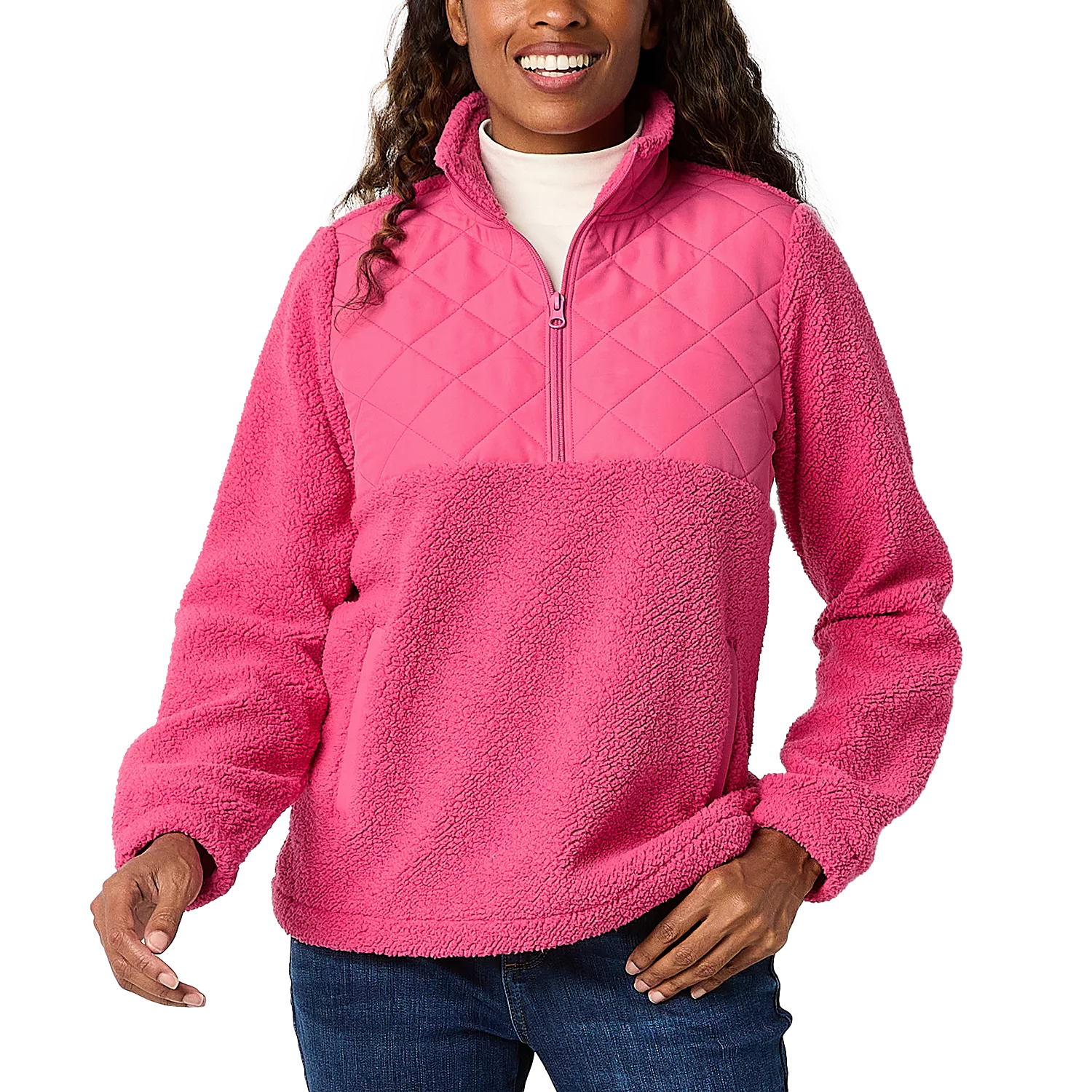 A woman is wearing a pink Sherpa quarter-zip pullover with a quilted upper chest and a fluffy lower half.