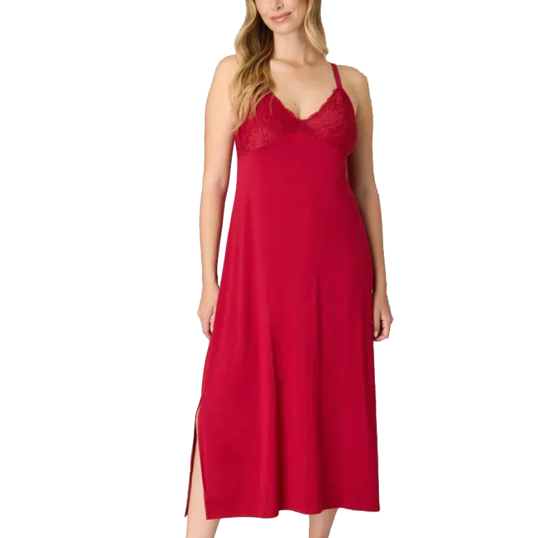 A woman is wearing a sleeveless red nightgown with lace detailing on the bodice and adjustable straps. The nightgown has a side slit.
