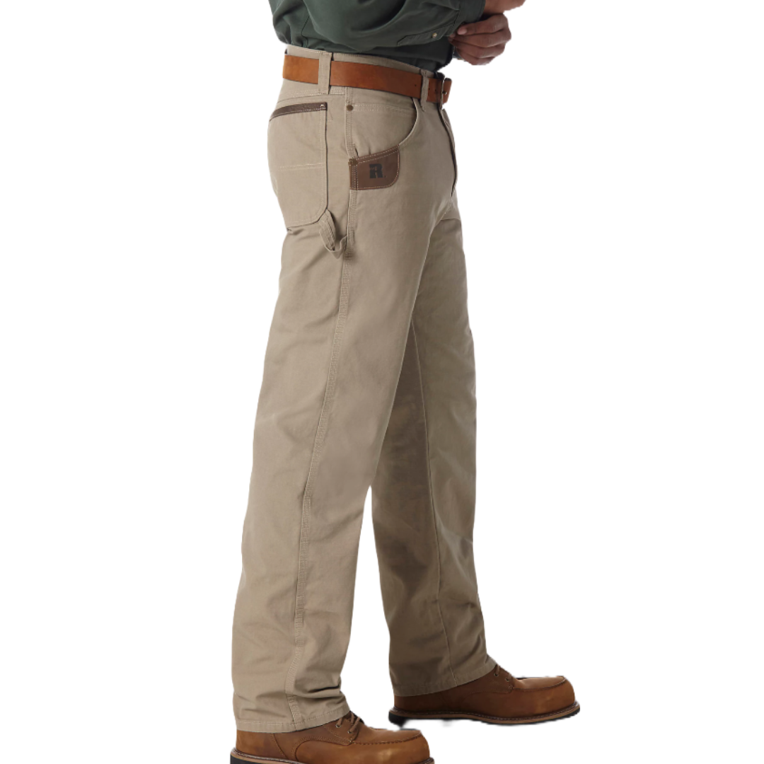 A person wearing khaki work pants with a leather belt and brown boots, featuring a small tool pocket on the side.