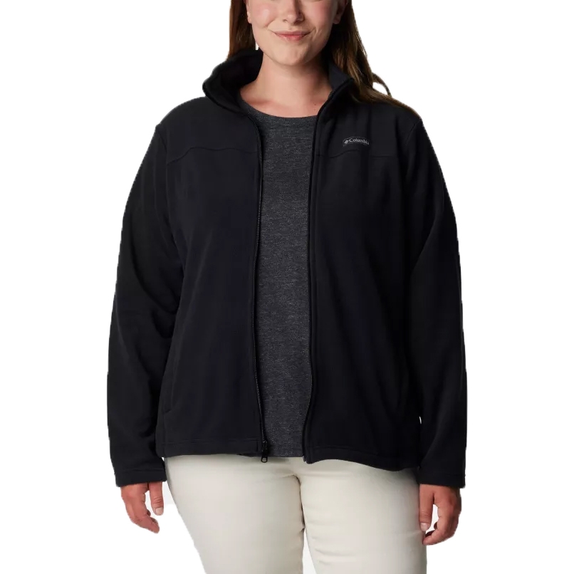 A woman wearing a black Columbia fleece jacket with a front zipper over a dark gray shirt and light pants.